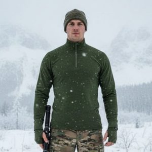 Chemise militaire en mérinos fermeture éclair, bonnet gris, tenue camouflage dans paysage enneigé avec neige tombant