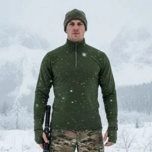 Chemise militaire en mérinos fermeture éclair, bonnet gris, tenue camouflage dans paysage enneigé avec neige tombant