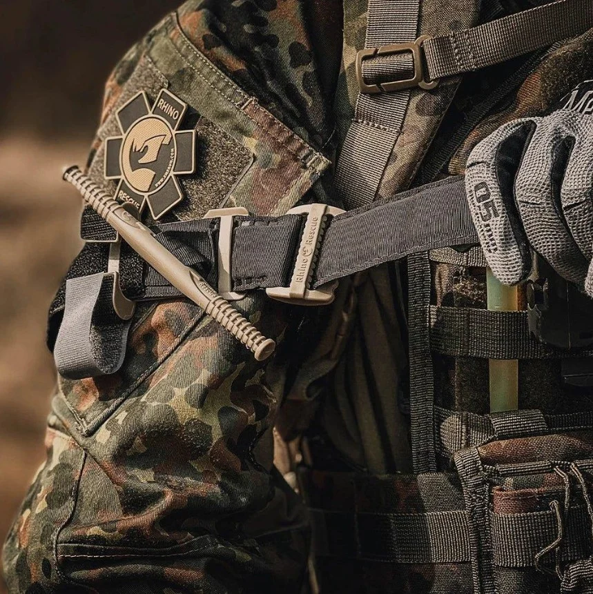 Porte-garrot tourniquet tactique RHINO RESCUE sur veste camouflage, attache rapide et sangle anx.