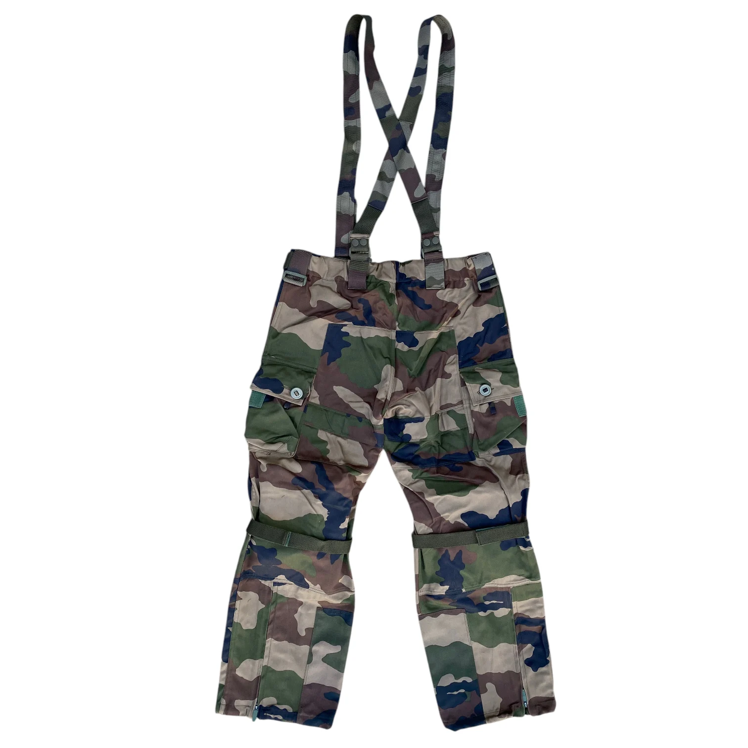 Pantalon treillis de combat camouflage avec bretelles assorties, rangé sur fond blanc.