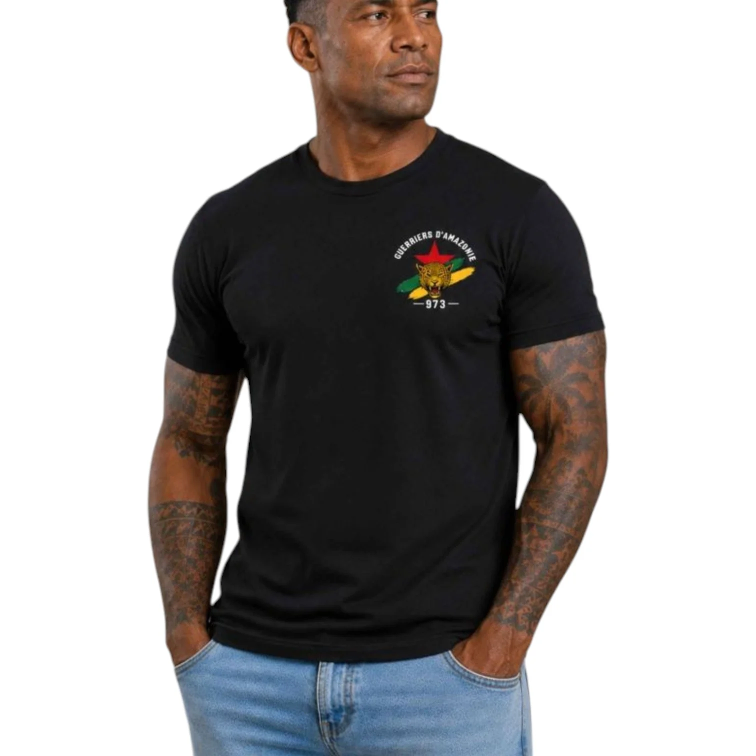 T‑shirt noir « Guerriers d’Amazonie » avec logo coloré sur la poitrine, homme sportif portant jean bleu clair. 973 Guyane. coton 190 g.