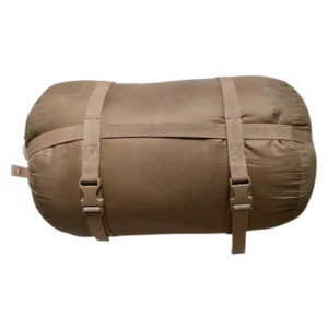 Sac de couchage roulé en couleur kaki avec sangles de fixation, prêt à être attaché pour le bivouac. sac de couchage de l armée française facilité de transport.