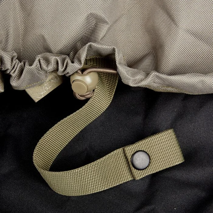Sangle élastique et bouchon de réglage d’un couvre-sac randonnée, gris et kaki, sur un sac noir.